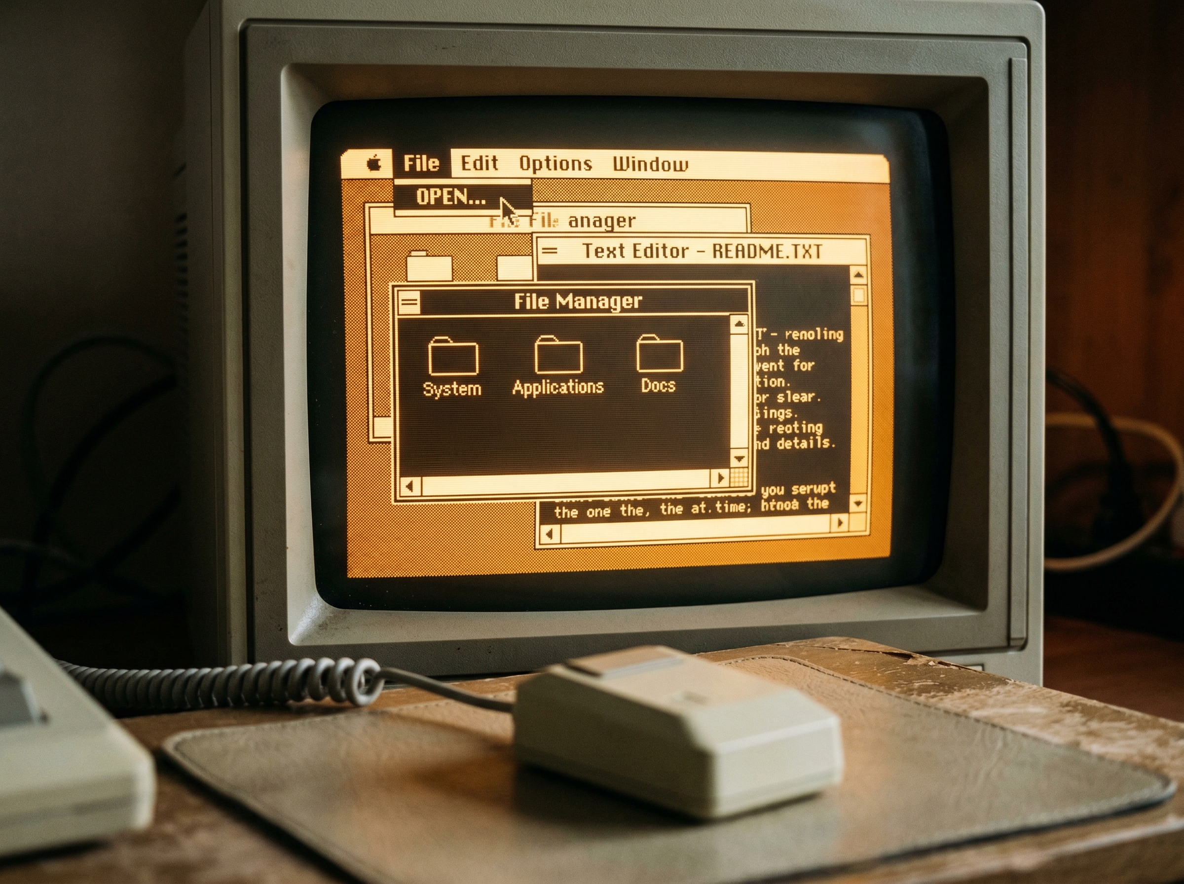 Close-up of a vintage 1983 computer monitor displaying a graphical user interface with overlapping windows and a mouse cursor