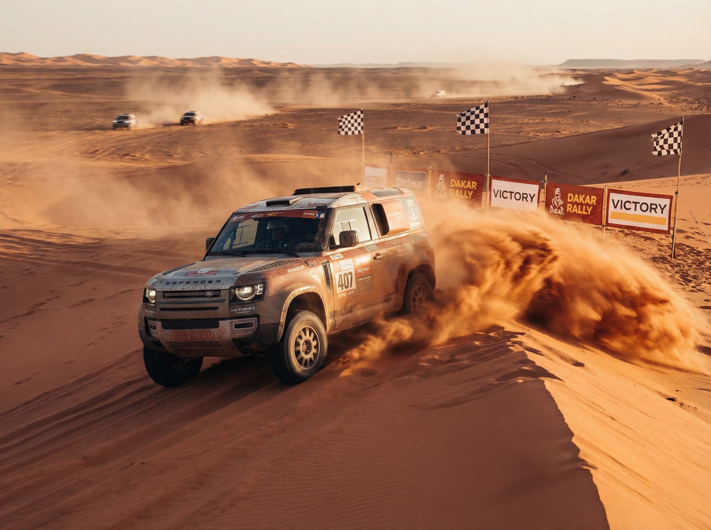 Land Rover Defender racing through Sahara dunes at Dakar Rally