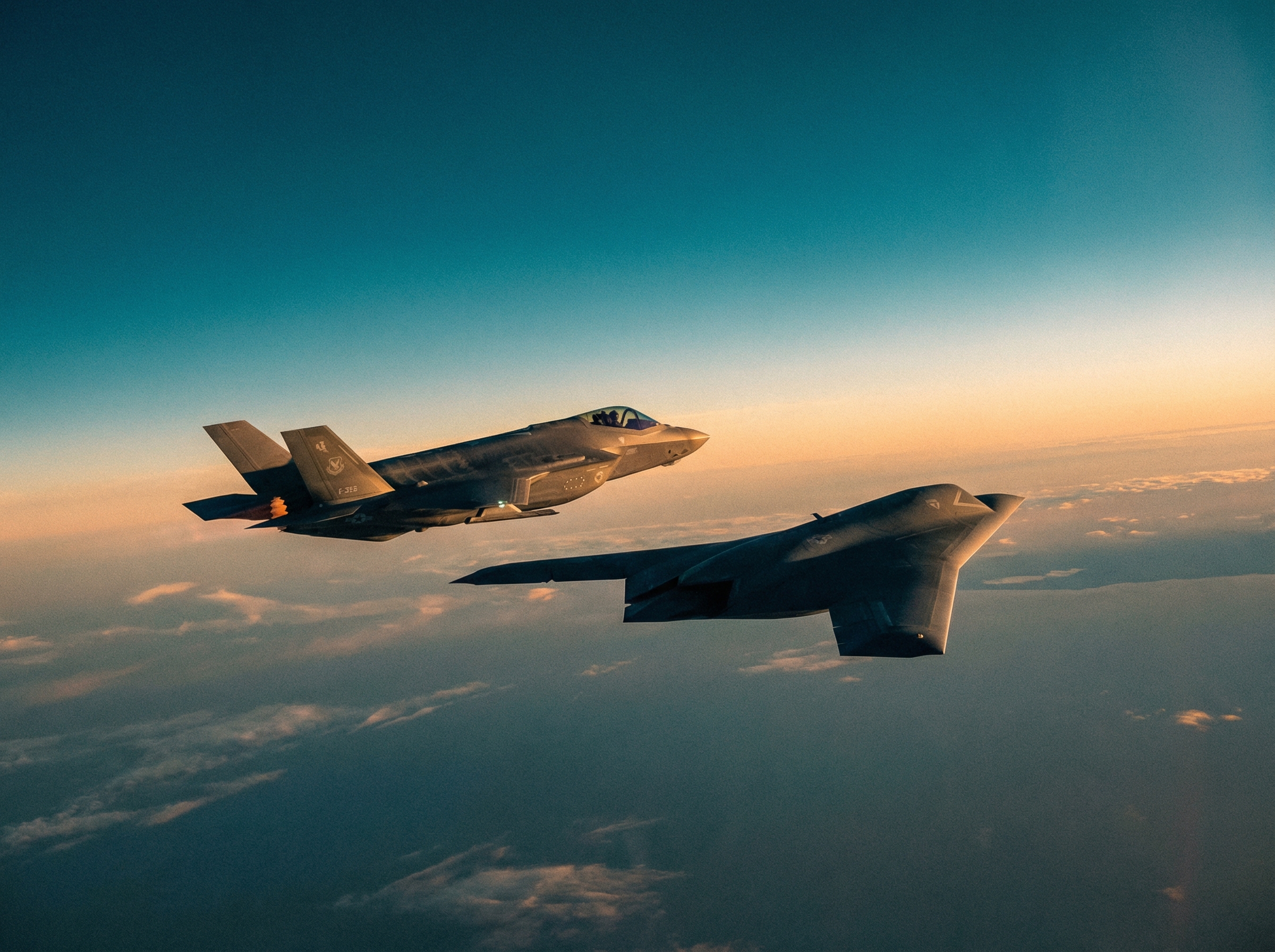 Stealth autonomous wingman drone flying alongside a manned fighter jet